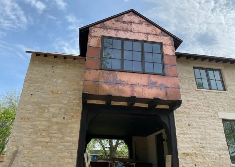 Copper metal panel facade on a stone building for Skylight Installation in La Porte