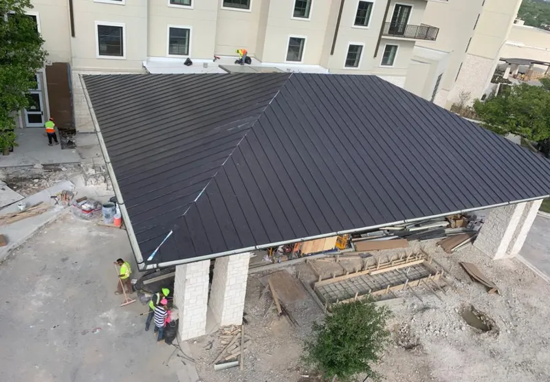 Metal roofing installation team working on a commercial building in La Porte